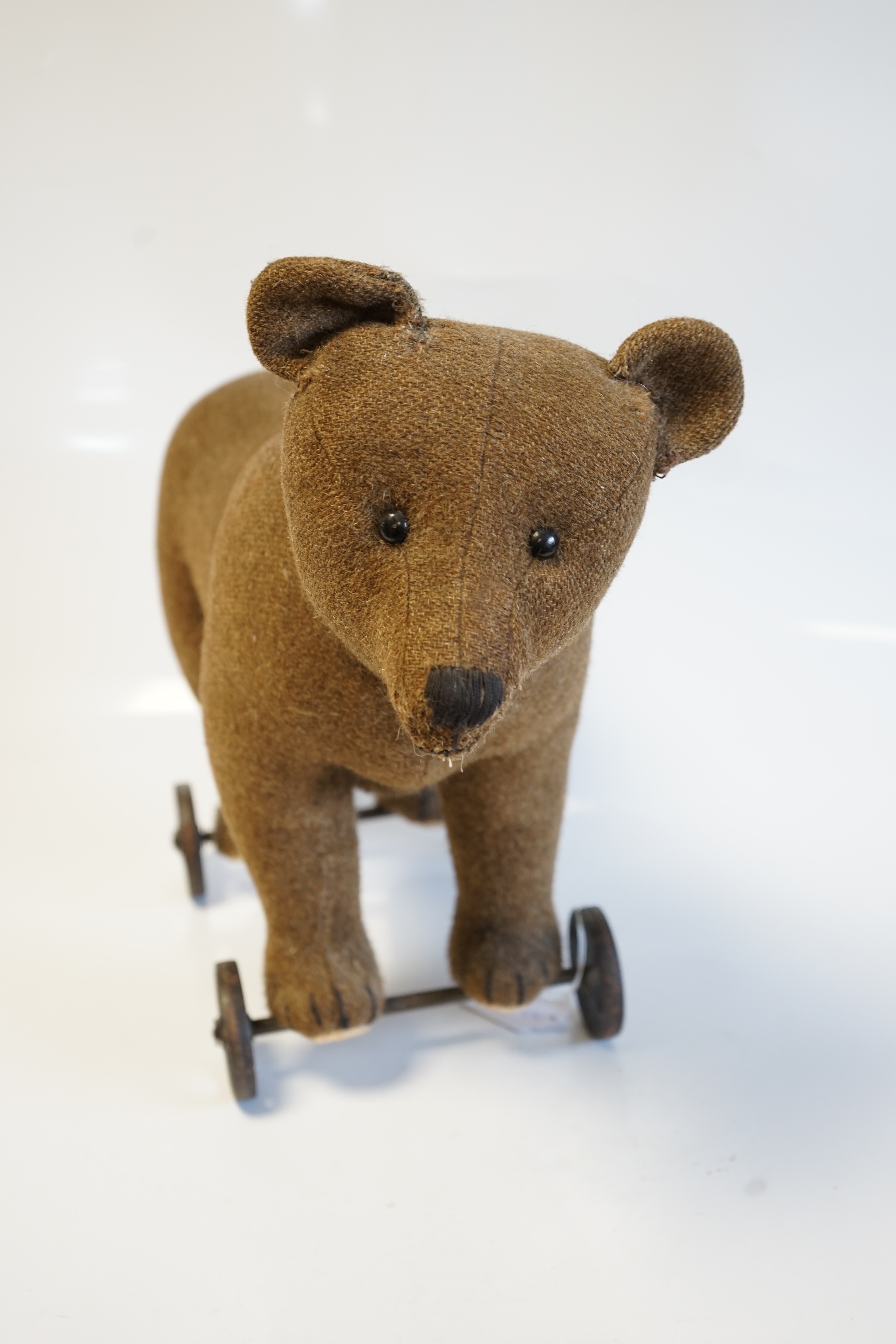 A Steiff bear on metal wheels, jointed head, no button, c.1910, 40cm high to top of head, 53cm length nose to tail. Condition - fair to good, some repair to neck otherwise in good condition